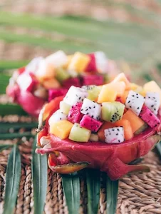 exotic-fruit-salad-served-half-dragon-fruit-palm-leaves-rattan-background-copy-space-tropical-travel-exotic-fruit-vegan-vegetarian-concept_769609-3528